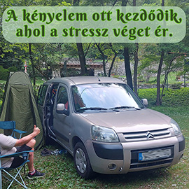 Camperes pihen az autó mellett az erdőben, kempingasztal, székek, és zuhanyzósátor van mellette.