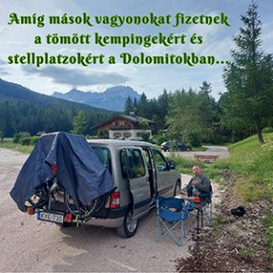 A camper mellett ülünk a kempingasztalnál, háttérben a Dolomitok csipkéi